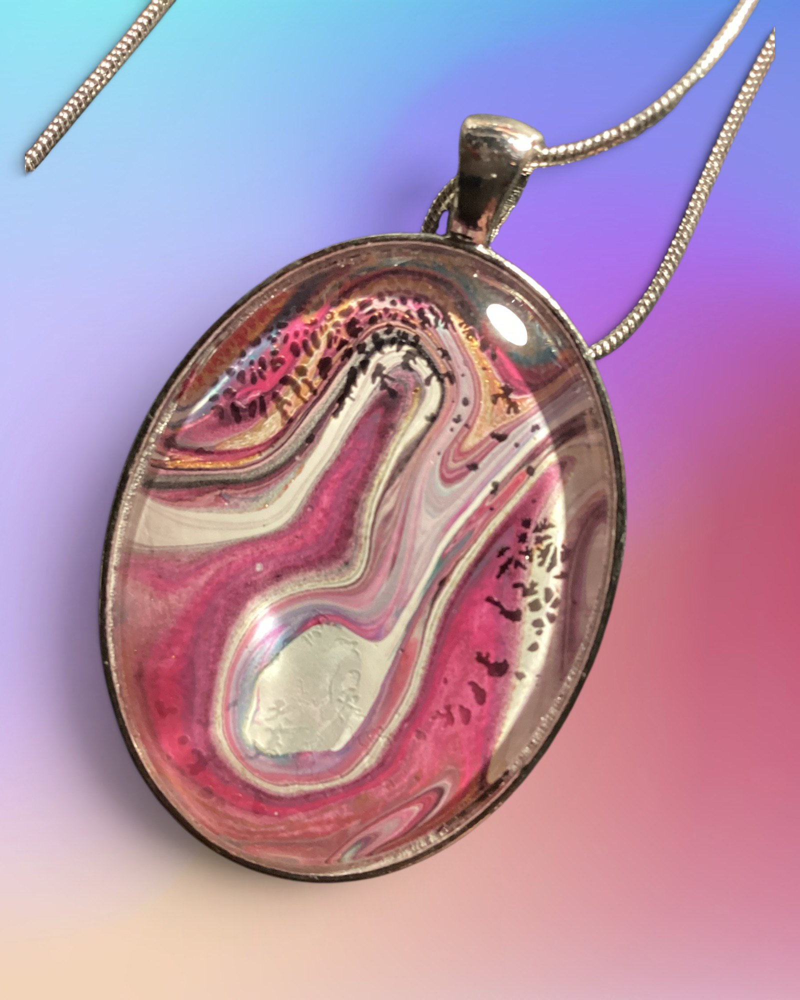 Heartfelt Creations oval pendant necklace with magenta, pink, and white acrylic pour art in a silver-tone setting.