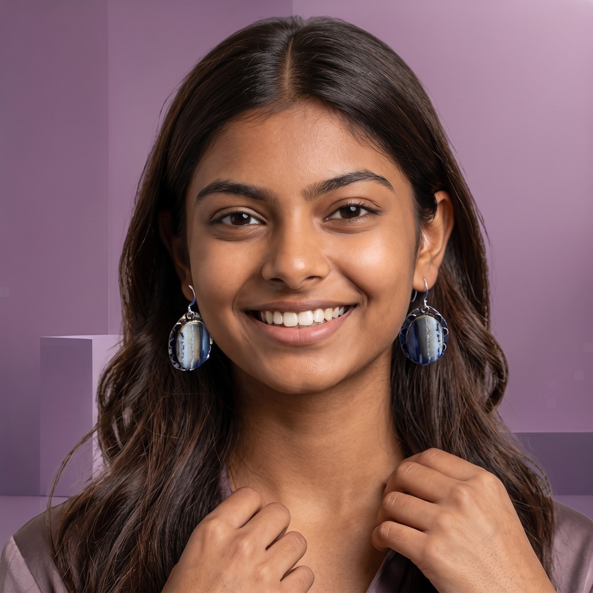 Heartfelt Creations oval drop earrings with grey and white banded stone in a scalloped metal frame worn by a woman.