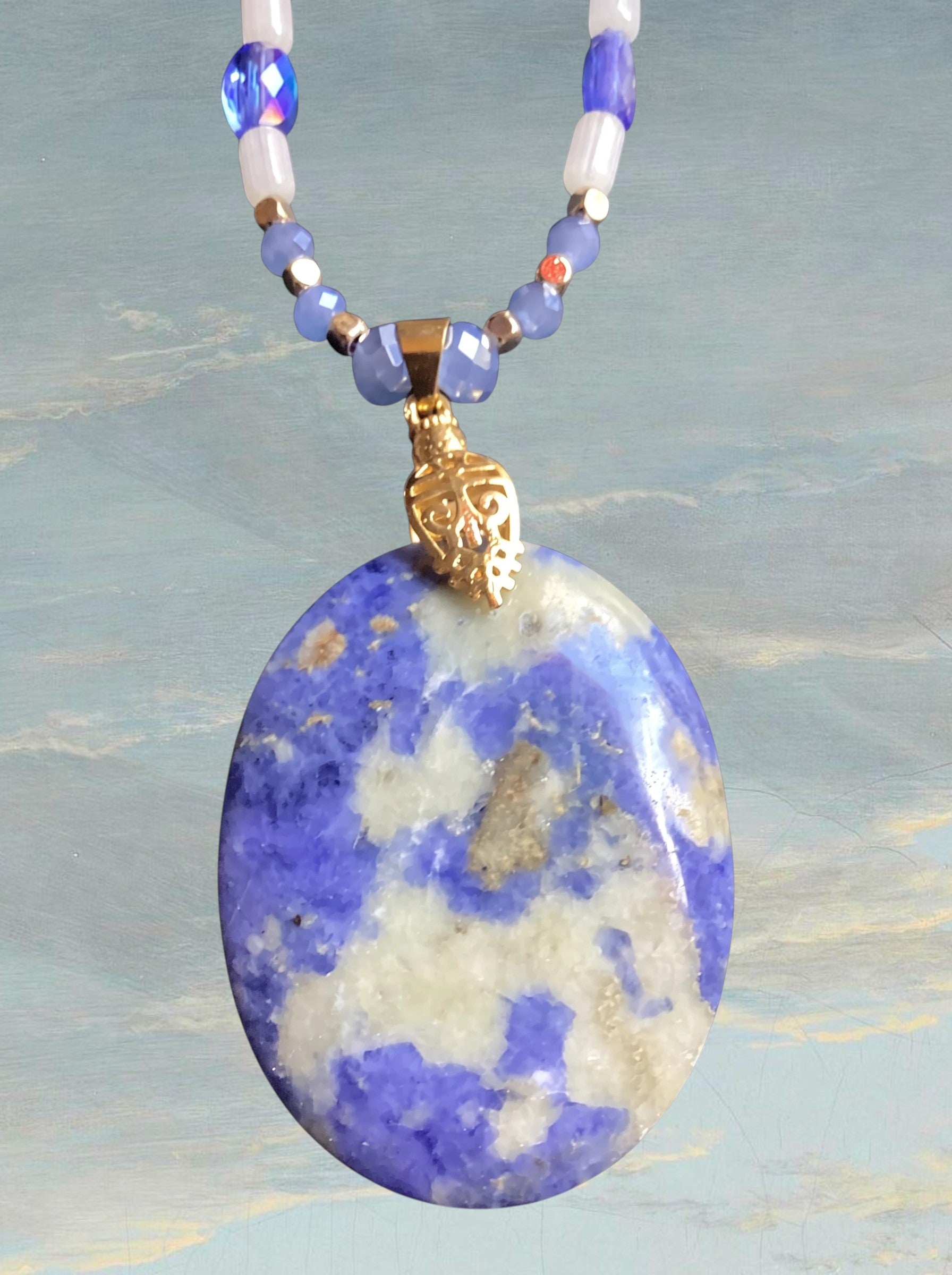 Heartfelt Creations artisan necklace featuring a large oval violet and white stone pendant on a beaded gold-tone chain