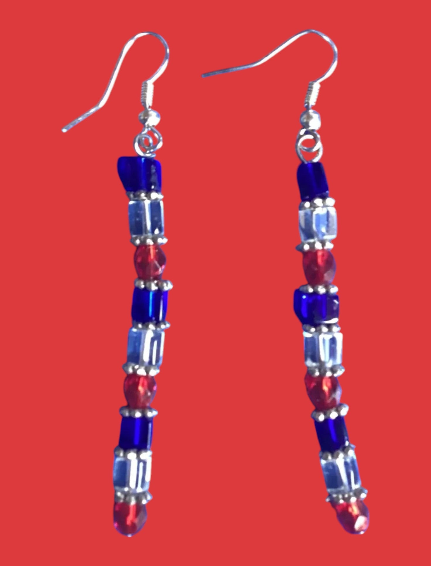 Heartfelt Creations handcrafted patriotic dangle earrings with red, white, and blue geometric beads on silver hooks.