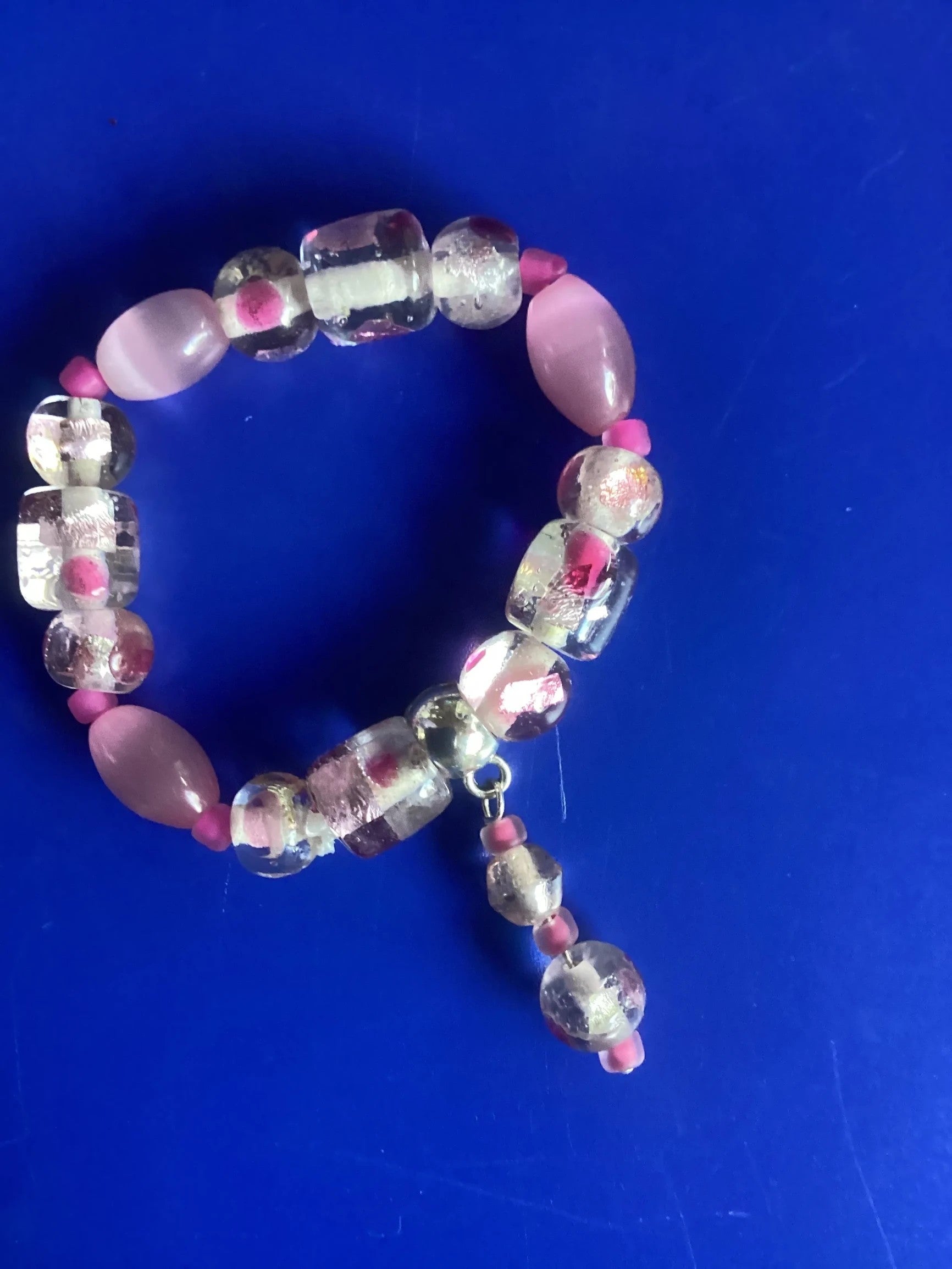 Heartfelt Creations beaded bracelet with clear glass beads, pink accents, and smooth pink stones. Stretchy band.
