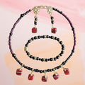 Heartfelt Creations beaded jewelry set with red and black dangle charms, gold-tone accents, necklace, and earrings.