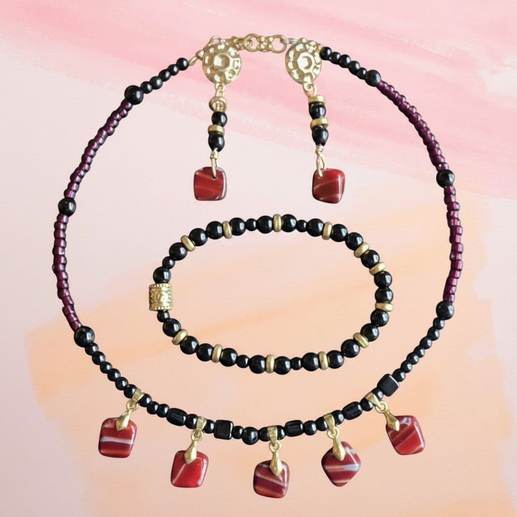 Heartfelt Creations beaded jewelry set with red and black dangle charms, gold-tone accents, necklace, and earrings.
