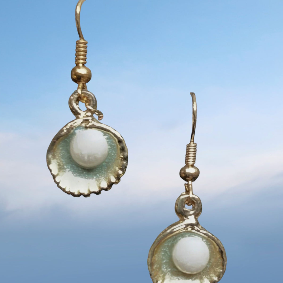Heartfelt Creations gold tone seashell pearl dangle earrings with intricate detail and lustrous finish.