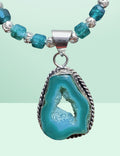 Heartfelt Creations bohemian necklace with a raw-edged teal geode pendant in a silver-tone setting and faceted beads.