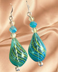Heartfelt Creations handcrafted teal teardrop glass earrings with lime green swirls and faceted blue bead accents.