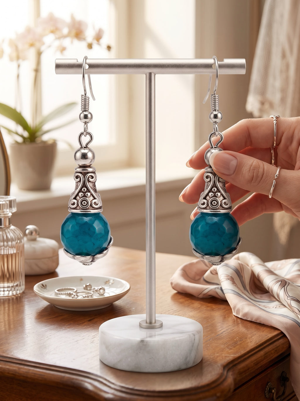 Heartfelt Creations ornate drop earrings featuring faceted teal stones and antiqued silver scrollwork on a display stand.