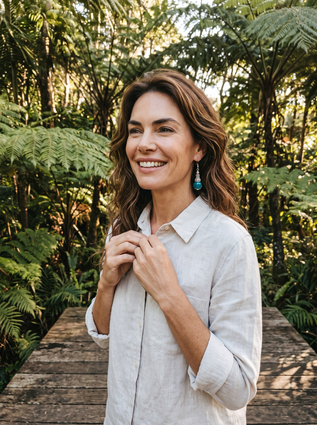 Heartfelt Creations ornate drop earrings with faceted teal stones and antiqued silver scrollwork worn by a smiling woman