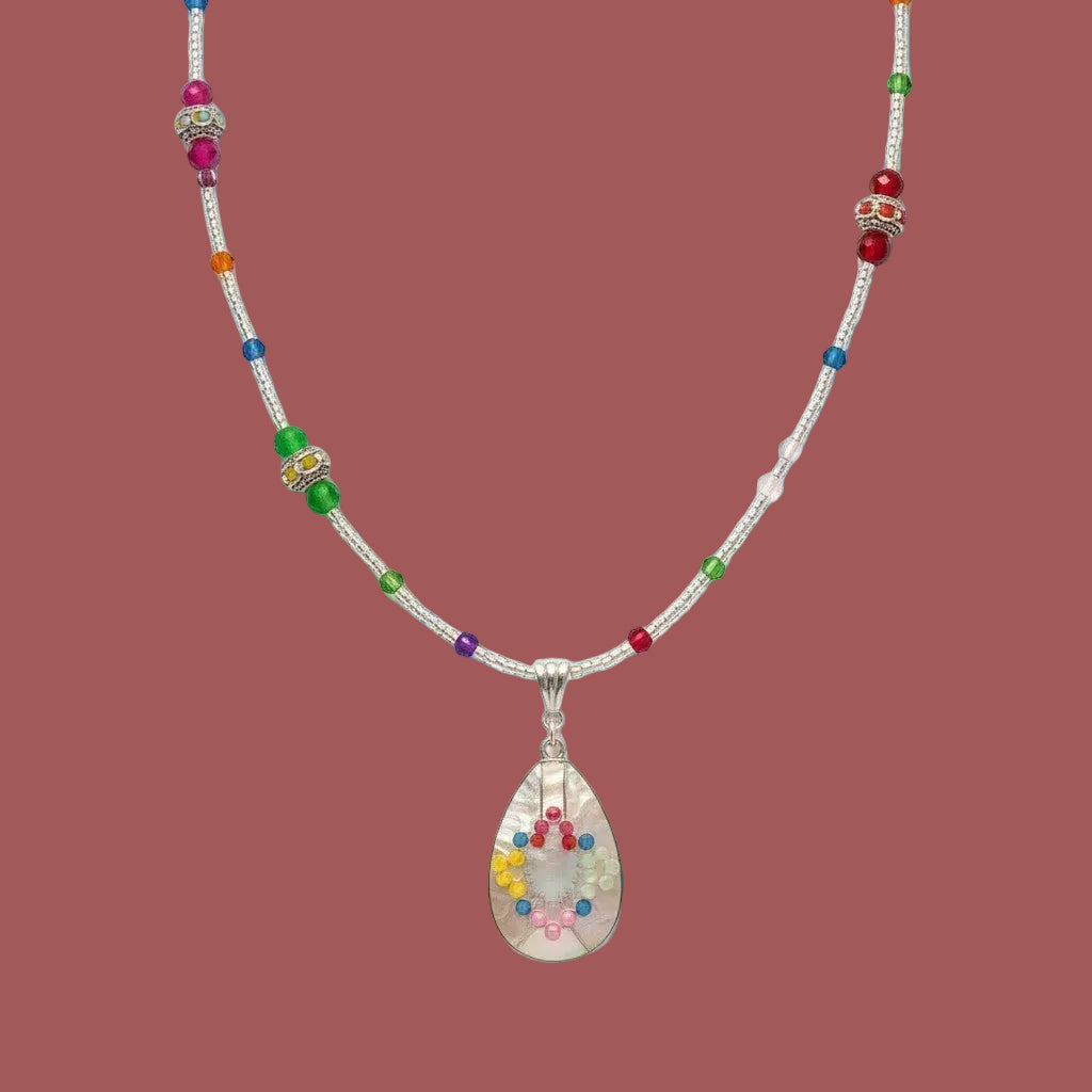 Heartfelt Creations teardrop pendant necklace with multi-colored crystals and a beaded chain on a white background.