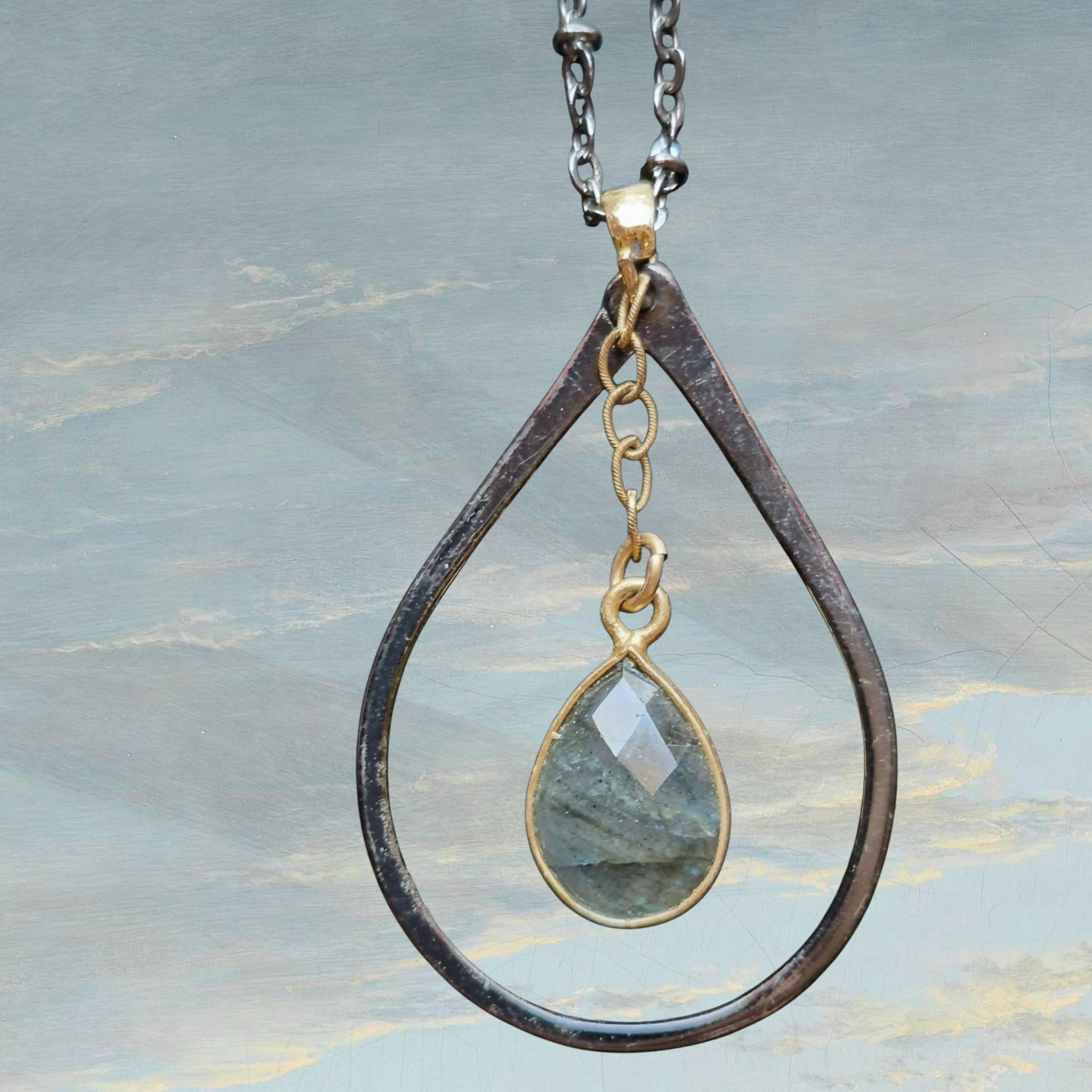 Heartfelt Creations teardrop pendant necklace with faceted labradorite gemstone and gold accents on a chain.