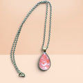 Heartfelt Creations teardrop pendant necklace with marbled coral resin inlay in an antique-bronze setting.