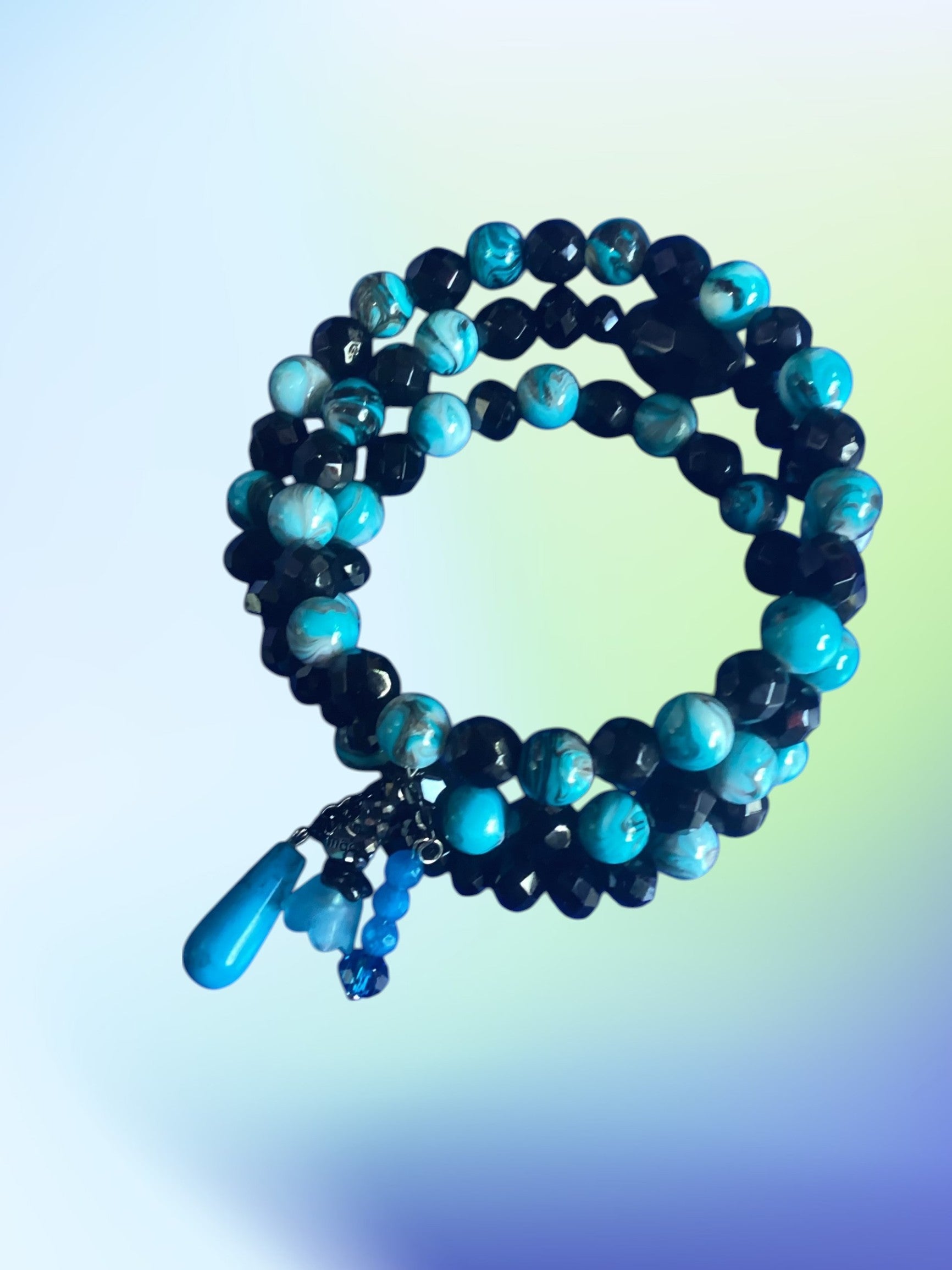 Heartfelt Creations turquoise and black beaded coil bracelet with charms. Elegant wrap design.