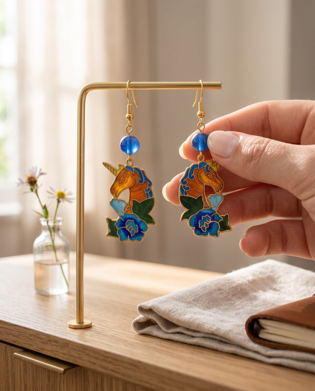 Heartfelt Creations unicorn dangle earrings with vibrant enamel floral details, gold-tone finish, and blue bead accents.