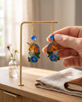 Heartfelt Creations unicorn dangle earrings with vibrant enamel floral details, gold-tone finish, and blue bead accents.