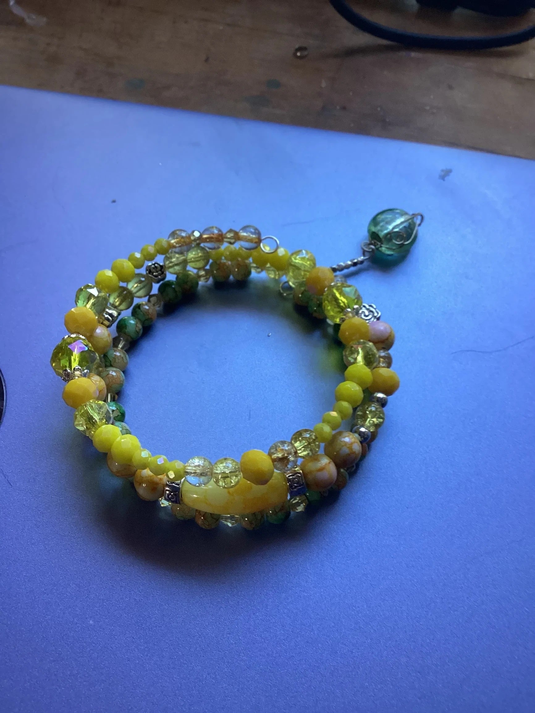 Heartfelt Creations yellow and green beaded wrap bracelet with charm. Features glass beads, natural stone-like beads, and silver spacers.