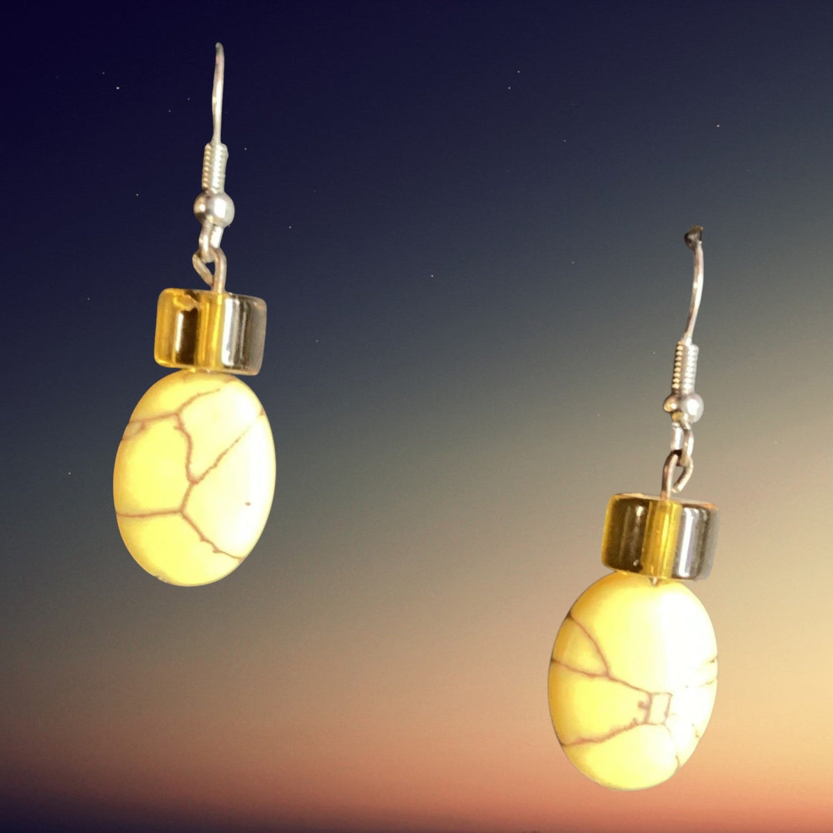 Heartfelt Creations oval yellow turquoise dangle earrings with amber beads and silver-tone hooks on a sunset background
