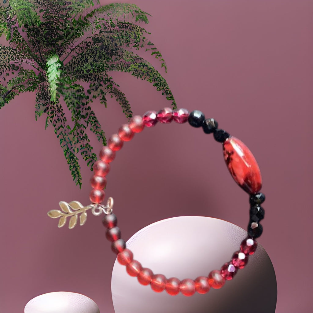 Heartfelt Creations beaded wire-wrap bracelet with crimson and black beads, a red focal bead, and a gold-toned leaf charm.