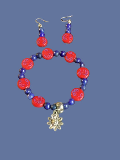 Beaded bracelet and earrings with a floral charm on a dark background