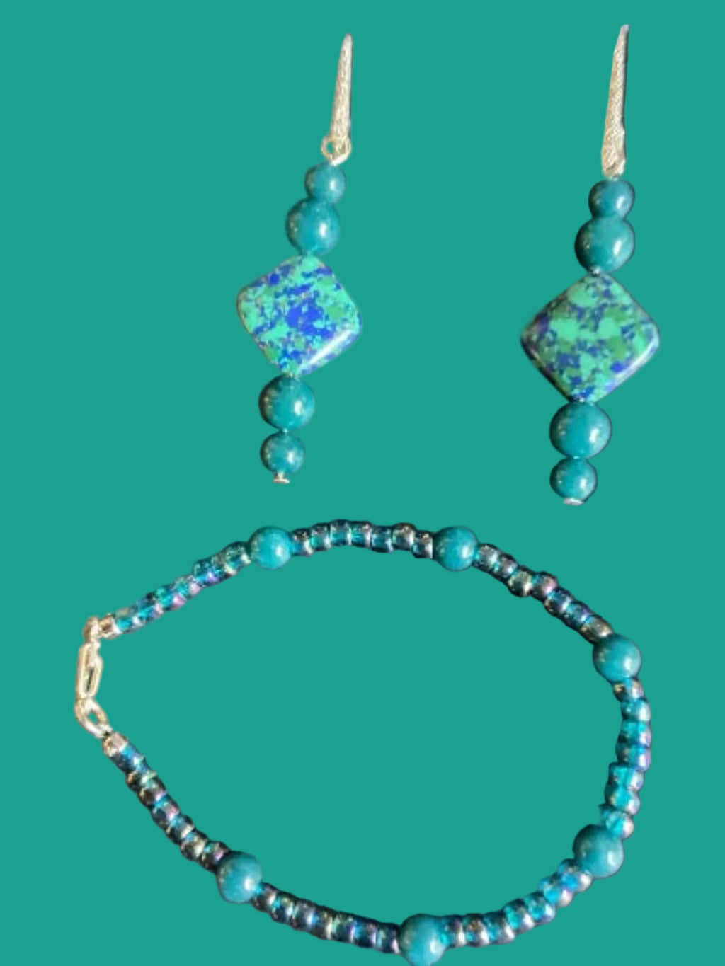 Turquoise beaded necklace and earrings on a dark green background
