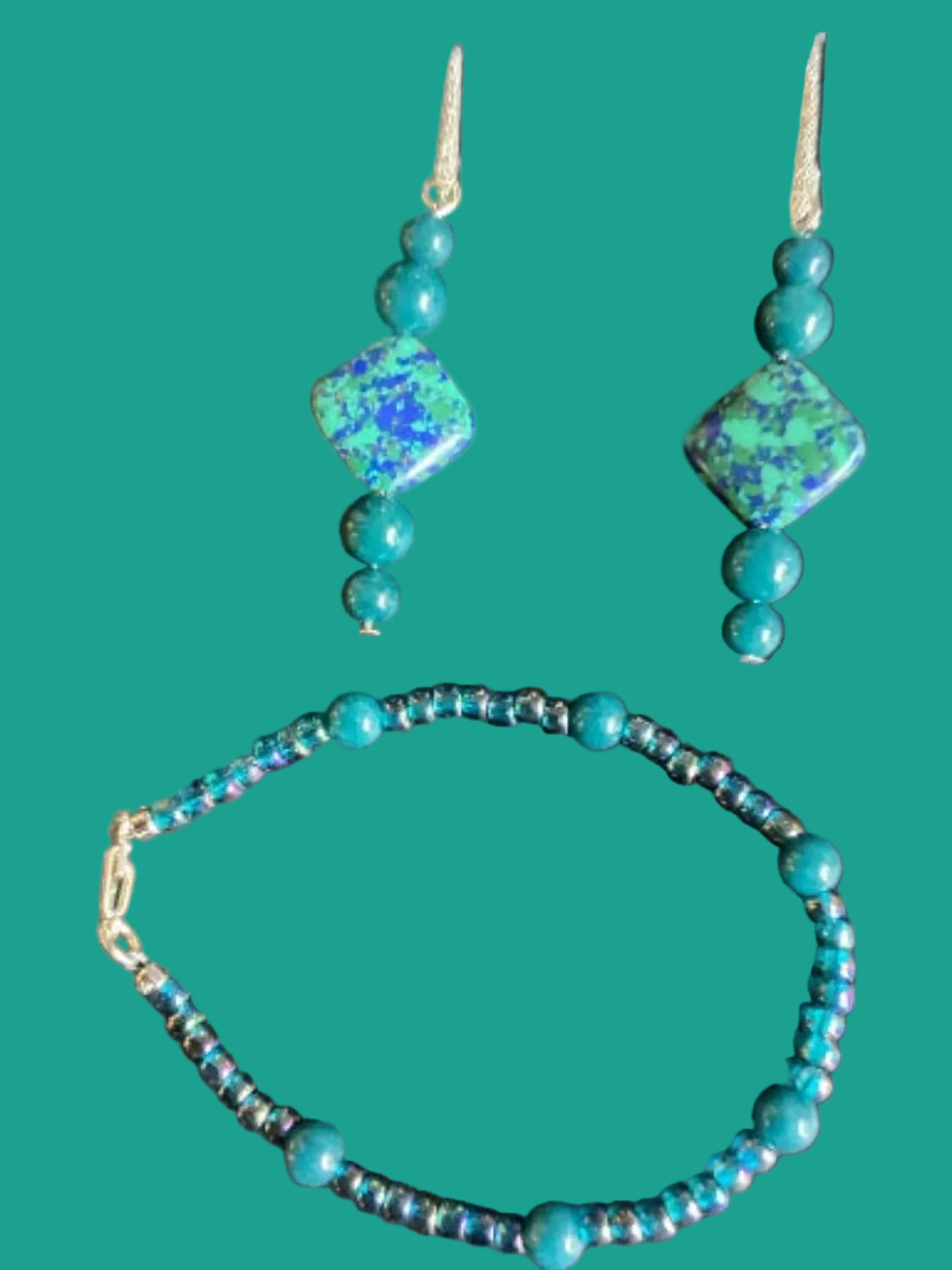 Turquoise beaded necklace and earrings on a dark green background