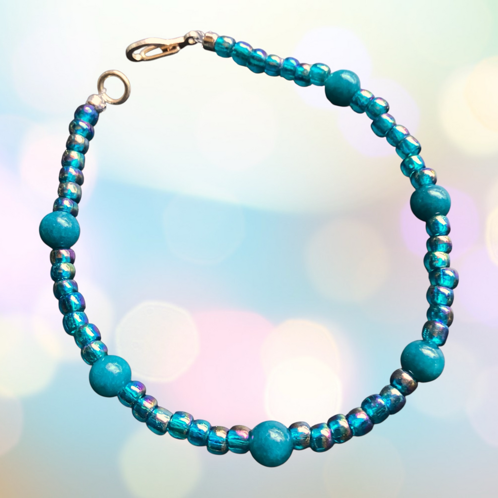 Turquoise beaded necklace with a clasp on a blurred colorful background