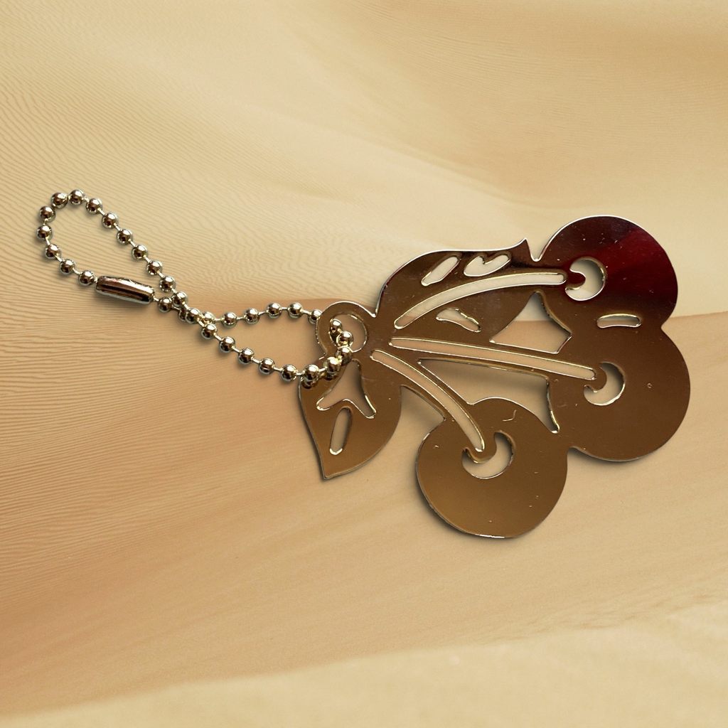 Hand-designed by Heartfelt Creations, you can add a touch of playful elegance to your everyday essentials with your choice of an 18k gold plated Brass cherry keychain or backpack/bag accessory