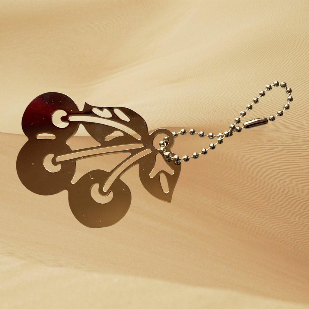 Hand-designed by Heartfelt Creations, you can add a touch of playful elegance to your everyday essentials with your choice of an 18k gold plated Brass cherry keychain or backpack/bag accessory
