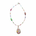 a delicate, handmade necklace featuring a thin, silver-toned chain adorned with small, multi-colored glass beads, leading to a teardrop-shaped pendant with a mosaic-like pattern of tiny, vibrant stones.